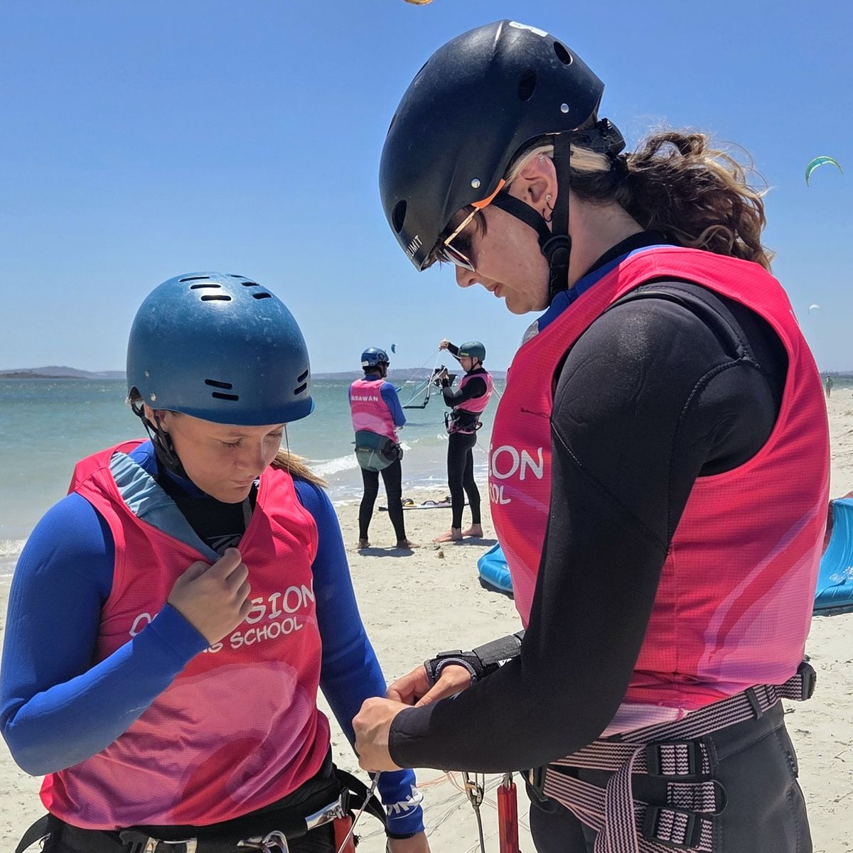 Obsession Kiting instructor fitting a harness on a student before a lesson