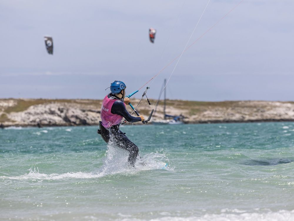 A kitesurfer carving a turn on the flat water of the Langebaan lagoon