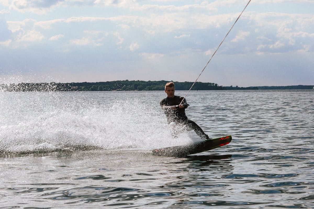 Wakeboarder riding behind a boat on flat water at Langebaan